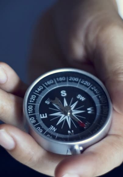 Businessman with a compass holding in hand, color tone film look